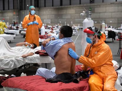 Profissionais sanitários atendem pacientes no pavilhão 5 da Ifema, habilitado como hospital de campanha, em Madri.