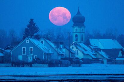 La luna llena detrás de la iglesia parroquial de Schoenach, cerca de Ratisbona, en el sur de Alemania.