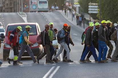 Un grupo de jornaleros del campo cruza caminan por Murcia tras su jornada laboral.