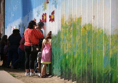 Varias personas hablan con familiares a través del muro que separa a México y los Estados Unidos, en Tijuana (México).