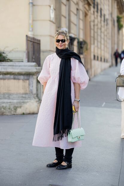 Hollie Mercedes Peters nos deja aquí una original combinación de prendas y estilos: un vestido en rosa pastel con mangas abullonadas, que mezcla con una bufanda extra larga de color negro, calentadores y merceditas a juego y un bolso de Chanel en verde menta.