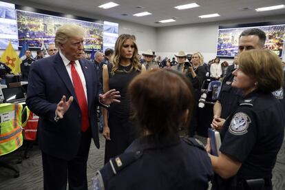 El presidente Donald Trump y la primera dama Melania Trump hablan con personal de seguridad mientras visitan el Centro Regional de Comunicaciones de El Paso.