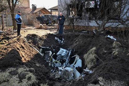 Un hombre toma imágenes de los restos de un misil ruso en el distrito Osokorky de Kiev, este martes. En Mariupol, una comitiva de 2.000 vehículos ha salido de la ciudad en uno de los nueve corredores humanitarios previstos para hoy en Ucrania.