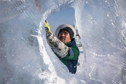 Un artista da forma a su escultura de hielo durante una competición celebrada en el Festival de Hielo y Nieve de Harbin. La competición de esculturas de hielo atrajo a 64 artistas de 12 países que pusieron a prueba su habilidad con hasta diez bloques de hielo por equipo.
