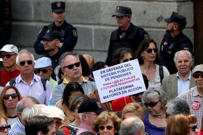 "En defensa del sistema público de pensiones" es el lema de un cartel que sostiene un manifestante durante la protesta por el centro de Madrid.
