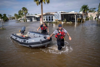 Dos agentes de los servicios de emergencia buscan supervivientes en una calle de Fort Myers.