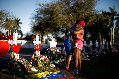 Adin Chistian, de 16 años, estudiante de la escuela de secundaria Stoneman Douglas, abraza a su madre Denyse junto a un altar improvisado en memoria a las víctimas del tiroteo en Parkland (Florida), el 19 de febrero de 2018.