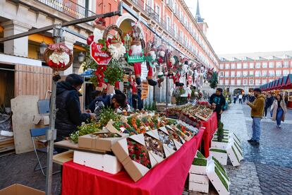 Varias personas visitan el Mercado de Navidad instalado en la plaza Mayor de Madrid.