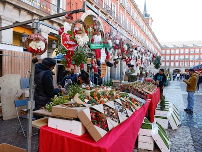 Varias personas visitan el Mercado de Navidad instalado en la plaza Mayor de Madrid.