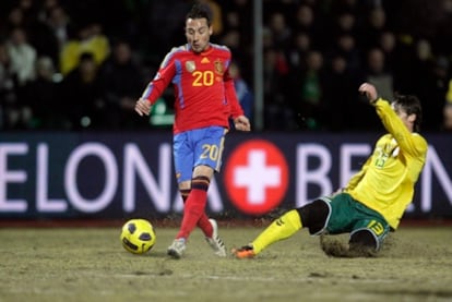 Cazorla recibe una entrada de un jugador lituano que levanta la arena del campo.