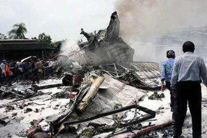 Residentes de la zona observan los restos del avión siniestrado en Medan, al norte de la isla indonesia de Sumatra.