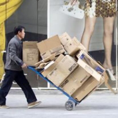 Un trabajador pasa frente a un escaparate de la firma Versace