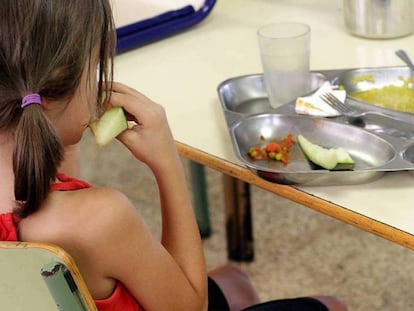 Una niña almuerza en un comedor escolar. 