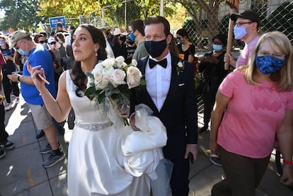 Unos recién casados ​​caminan en las calles de Washington mientras la gente celebra el triunfo de Joe Biden.