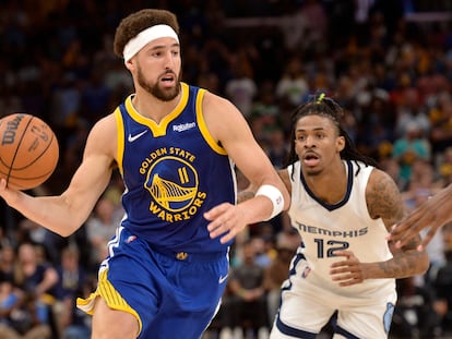 Klay Thompson (Golden State Warriors) conduce el balón este lunes ante la presencia de Ja Morant, estrella de los Memphis Grizzlies.