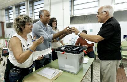 Un hombre vota en una mesa de la escuela.