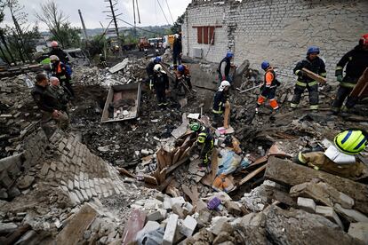 Bomberos y soldados ucranios buscan cadáveres entre los restos de un edificio que fue atacado por las tropas rusas, este miércoles en la ciudad recién liberada de Izium.