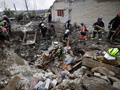 Bomberos y soldados ucranios buscan cadáveres entre los restos de un edificio que fue atacado por las tropas rusas, este miércoles en la ciudad recién liberada de Izium.