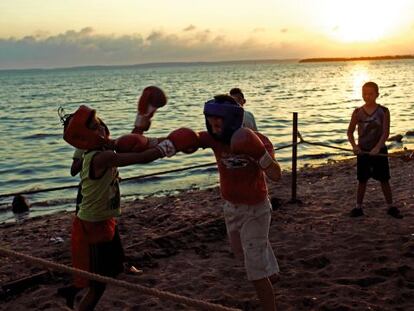 Durante el ocaso en una playa de Cienfuegos, un grupo de muchachos se ejercita en el boxeo.