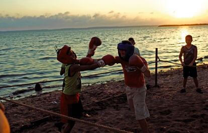 Durante el ocaso en una playa de Cienfuegos, un grupo de muchachos se ejercita en el boxeo.