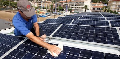 A worker installs solar panels at the Club Nautico de L'Estartit (Girona).