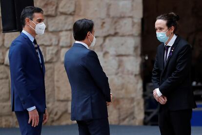 El presidente español, Pedro Sánchez (izquierda), y el presidente italiano, Giuseppe Conte (centro), saludan al vicepresidente  Pablo Iglesias, durante la recepción en el patio de honor del palacio de la Almudaina, en el que se celebra la XIX Cumbre Bilateral de España e Italia, este miércoles en Palma de Mallorca.