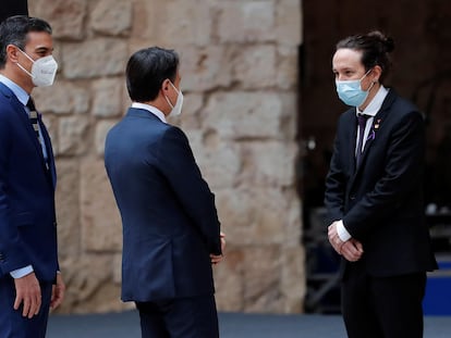 El presidente español, Pedro Sánchez (izquierda), y el presidente italiano, Giuseppe Conte (centro), saludan al vicepresidente  Pablo Iglesias, durante la recepción en el patio de honor del palacio de la Almudaina, en el que se celebra la XIX Cumbre Bilateral de España e Italia, este miércoles en Palma de Mallorca.