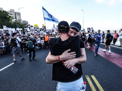 Dos hombres se abrazan en un momento de la marcha.