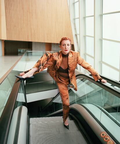 Jenny Walker Jenny: «Con este traje de chaqueta con pelos de Schiaparelli pienso en Christopher Walken bailando en las escaleras mecánicas. Un cruce de sentidos y de formas». La artista visual es también docente en la universidad HEAD Haute École d’Art et Design: «A mí, que no soy universitaria, esto me parecía una gamberrada total. Pero me lo ofrecieron y me di cuenta de la modernidad y contemporaneidad de algunas instituciones en las que solo con la experiencia, habérmelo currado durante mucho tiempo, haber observado y analizado es suficiente para ejercer. En muchos países si no tienes un título universitario no te lo permiten». (La coreógrafa lleva un traje de raso estampado y body de tul, ambos de SCHIAPARELLI; salones de cuero de BALENCIAGA y pendiente en la oreja izquierda de ACNE STUDIOS.)