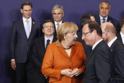 La canciller alemana Angela Merkel (i) conversa con el presidente francés François Hollande (d) durante la foto de familia de la cumbre de jefes de Estado y de Gobierno de la Unión Europea (UE) en Bruselas, Bélgica, hoy, jueves 18 de octubre de 2012.