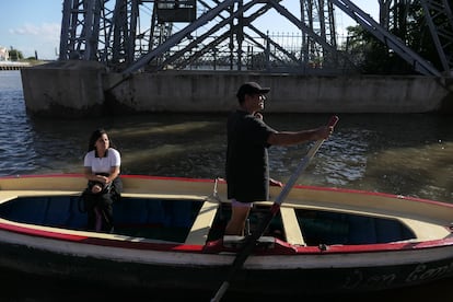 Un hombre transporta a una mujer abordo de una balsa a travs del Riachuelo, en el barrio de La Boca, este 12 de febrero. 