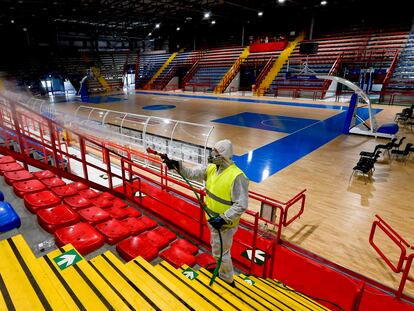 Um agente dos Serviços de saúde de Nápoles higieniza as instalações esportivas do ginásio Palabaruto.