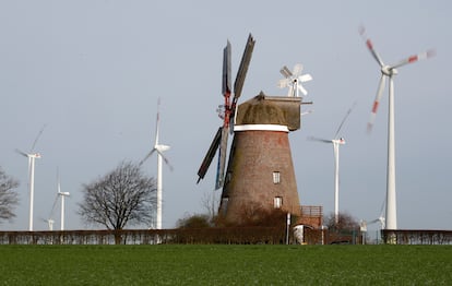 Un molino antiguo, frente a un parque eólico en Breberen (Alemania).