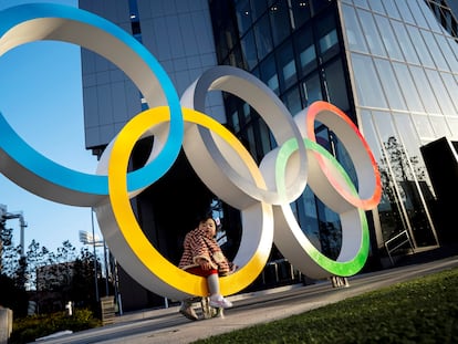 A child poses for photographs with the Olympic rings in front of the Japan Olympic Museum in Tokyo , Japan, February 17, 2020. REUTERS/Athit Perawongmetha
