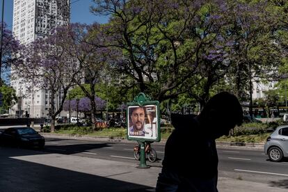 Un transeúnte pasa frente a uno de los carteles de propaganda electoral.