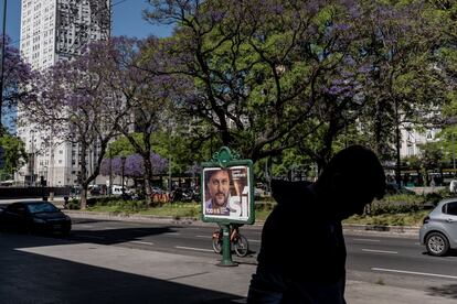 Un transeúnte pasa frente a uno de los carteles de propaganda electoral. 