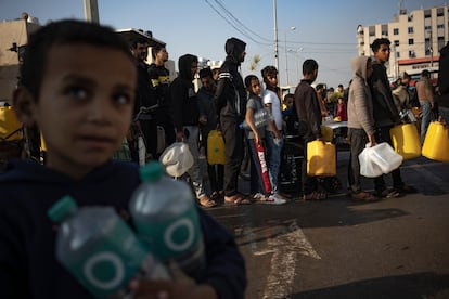 Un grupo de palestinos hace cola para recoger agua en Muwasi, al sur de la Franja, este lunes. 