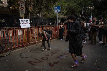 Manifestantes escriben consignas contra el gobierno de Daniel Noboa en la protesta por la redada de la embajada mexicana en Quito.