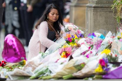 Una mujer deposita una flores en homenaje a las víctimas del atentado en el Mánchester Arena, 24 de mayo de 2017.
