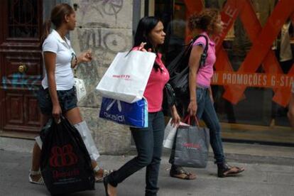 Tres mujeres caminan ayer con compras por la calle de Fuencarral de Madrid.