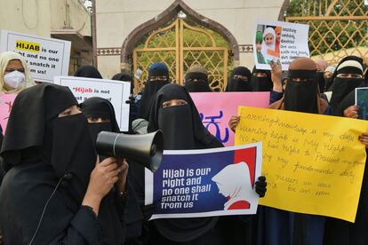 Varias mujeres musulmanas sostienen pancartas durante una protesta por la decisión de los institutos educativos de Karnataka de negar la entrada a las estudiantes por usar hijabs, en Bangalore (la India).
