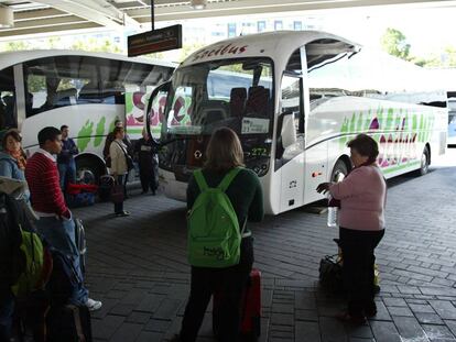Varios pasajeros en las dársenas de la Estacion Sur de Autobuses de Madrid.