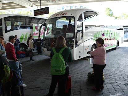 Varios pasajeros en las dársenas de la Estacion Sur de Autobuses de Madrid.