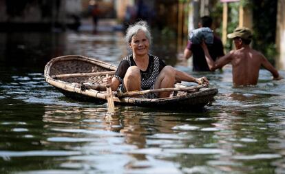 Una mujer vietnamita navega por una zona inundada en el municipio de Nam Phuong Tien, distrito de Chuong My en Hanói (Vietnam).