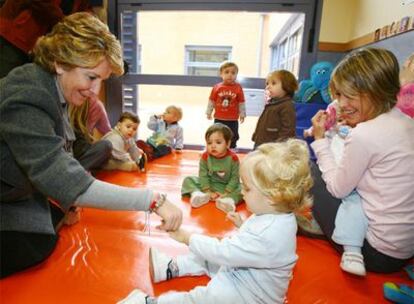 Esperanza Aguirre juega con una niña de la guardería Sol Solito, financiada por la Comunidad de Madrid.