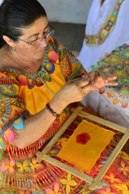 Mujer guaraní tejiendo un ñandutí o encaje.