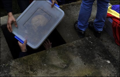 Voluntarios de la Asociación para la Recuperación de la Memoria Histórica (ARMH) introducen en un nicho del cementerio de Valdeoceda (Brugos) restos humanos exhumados de una fosa común, el 14 de septiembre de 2013.