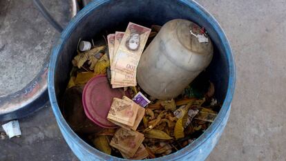 Billetes antiguos de 100 bolívares en un cubo de basura en Caracas.