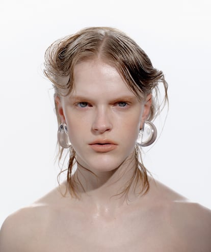 El aceite capilar Honey Infused Hair Oil, de GISOU, se aplica de raíz a puntas como tratamiento de choque.Pendientes media luna de GIORGIO ARMANI.
