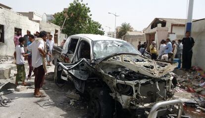 Ciudadanos observan el estado en que ha quedado el coche despu&eacute;s del atentado suicida del lunes. 